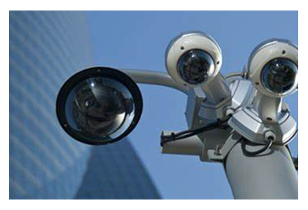 Security cameras on a pole with a building in the background